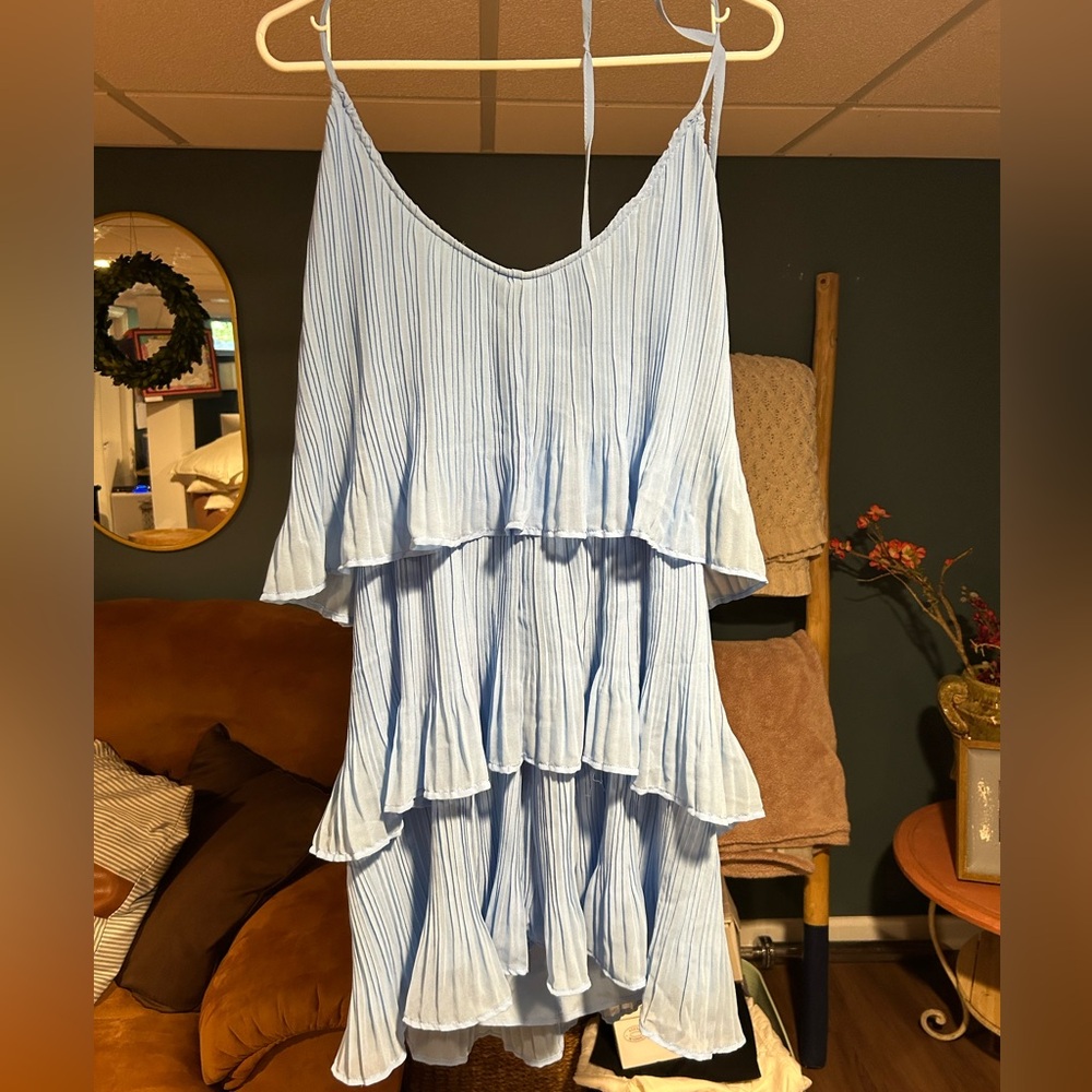 Blue pleated tiered dress with halter tie around neck.
